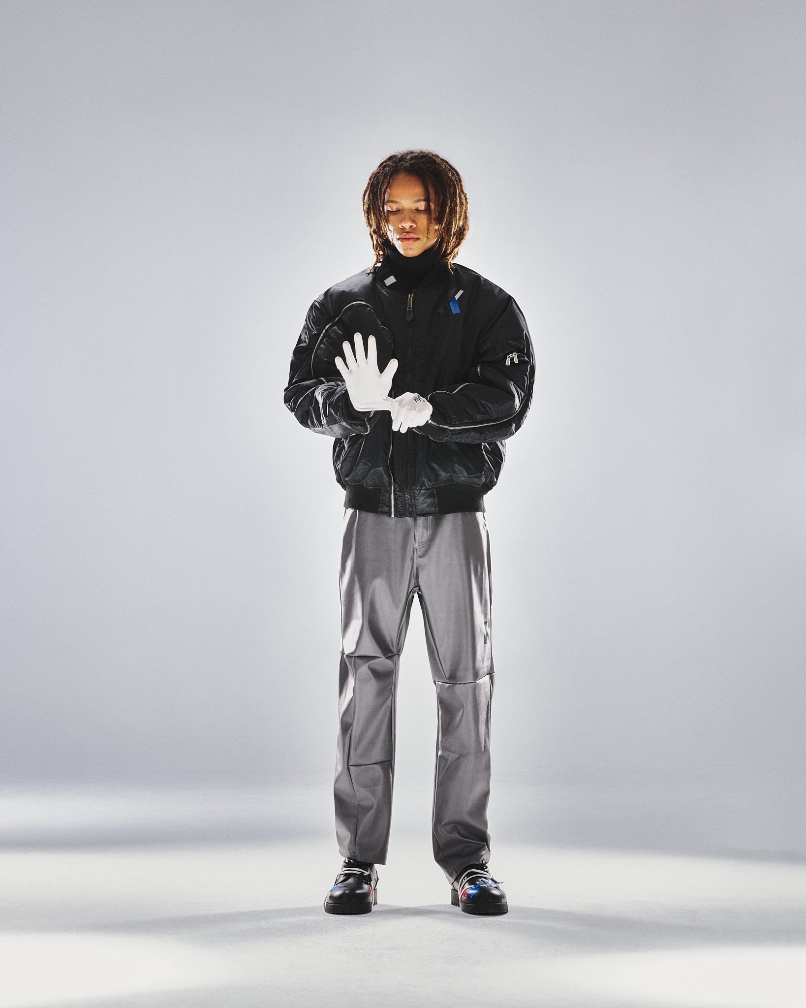 Glänzende Bomberjacke, silberne Hose, weiße Handschuhe